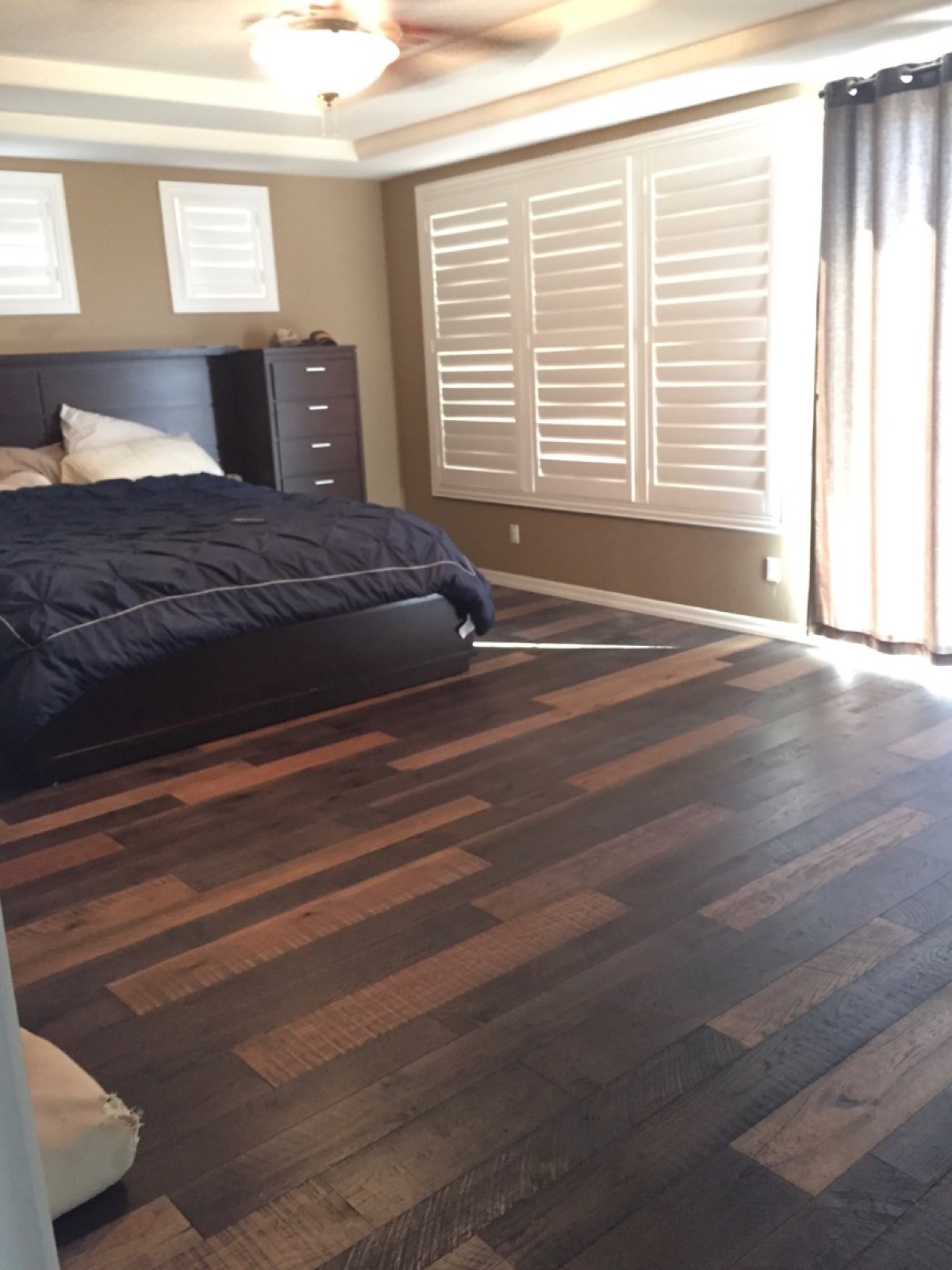 Master bedroom with a multi-tone mixed-width rustic plank floor